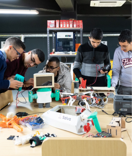 Five students work on a robot.