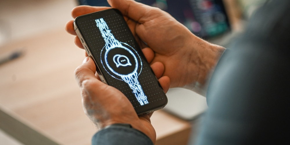 Une personne regarde son téléphone qui affiche des éléments numériques. 