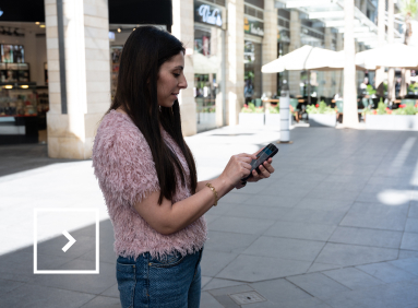Une femme regarde son téléphone dans la rue
